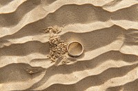 Wedding ring on sand backgrounds outdoors jewelry.