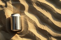 Beer can on sand outdoors refreshment container.