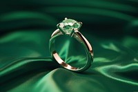 1 simple emerald ring on green background gemstone jewelry accessories.