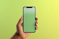 Hand holding smartphone green background