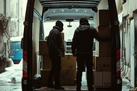 Two workers loading boxes inside of a van vehicle adult car.