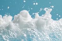 Textured bubbling foam on blue background milk snow splashing.