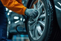 Car service worker polishing car wheels with microfiber cloth vehicle spoke adult.