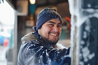 A smiling male hispanic worker in car wash photography portrait outdoors.