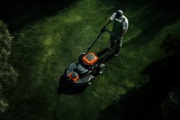 Man mowing grass lawn plant mower.