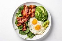 Keto friendly low carb breakfast plate with sunny side up eggs spinach avocado bacon.