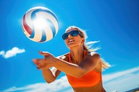 Beach volleyball player in action at sunny day under blue sky glasses sports beach.