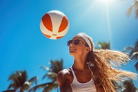 Beach volleyball player in action at sunny day under blue sky sports beach sunglasses.