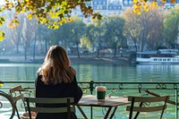 Woman drinking a coffee at a table furniture outdoors sitting.