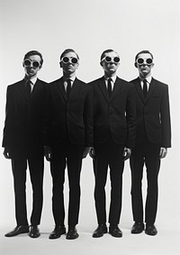 A four cool man wearing black suit and black sunglasses photography accessories groupshot.