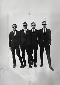 A four cool man wearing black suit and black sunglasses photography accessories groupshot.