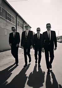 Four man wearing black suit and black sunglasses accessories groupshot accessory.