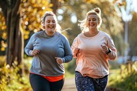 Two happy chubby women jogging together in city park running adult determination.