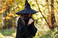 Woman dressed as a witch holding adult black.
