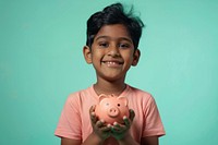 Indian kid holding a piggybank happy person female.