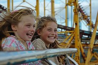 Young girls on roller coaster outdoors child fun.