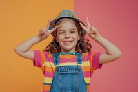 Photo of female kid with 2 finger pose portrait photography clothing.