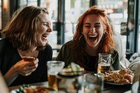 Two happy female having meal and beer and laughing drink adult food.