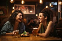 Two happy female having meal and beer and laughing drink adult togetherness.