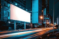 Blank billboard mockup of office buildings in the night city street transportation advertisement.