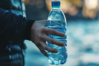 Close up of person holding water bottle drink refreshment drinkware.