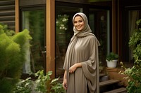 Arab adult woman standing hijab plant.