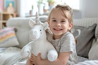 Kid holding unicorn doll portrait smile white.