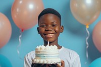 Lovely teenage African boy balloon happy cake.