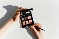 Hand hold eyeshadow palette cosmetics perfume makeup.