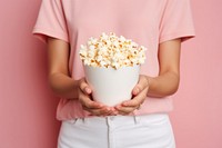 Photo of women holding popcorn on pink background adult food midsection.