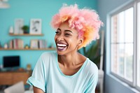 A black woman with white casual home attire and bright hair color smiling electronics laughing hardware.