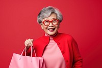 Happy senior Taiwanese lady holding shopping bags accessories surprised accessory.