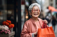 Happy senior Taiwanese lady holding shopping bags accessories accessory laughing.