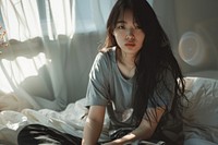 Asian girl looking tired sitting on bed portrait photo contemplation.