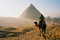 Bedouin on camel pyramid architecture desert.