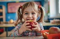 Little girl eating apple produce biting person.
