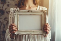 Woman holding vintage picture frame mockup painting wedding female.