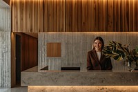 A happy woman behind a front desk architecture lobby reception.