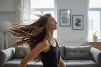 Woman dancing in iving room couch head hair.