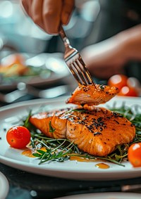 A person using silverware salmon plate cutlery.