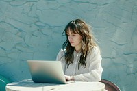 Woman working on a laptop computer sitting photo.