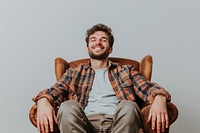 Happy man sitting on the armchair furniture laughing portrait.