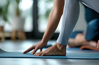 Yoga teacher move leg of a yoga student exercise fitness female.