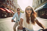 Photo of friends riding a bicycle traveling in town laughing vehicle glasses.