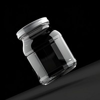 Clear jam jar bottle with white label black black background monochrome.