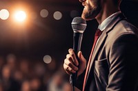 Motivational speaker with microphone performing on stage adult performance accessories.