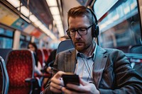 Businessman sitting on a train headphones adult portability.