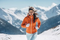 Woman wearing winter exercise clothes running snow mountain.