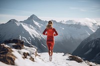 Woman running on snowy mountain jogging adult mountaineering.