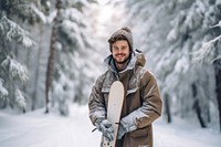 Man carrying snowboard portrait outdoors winter.